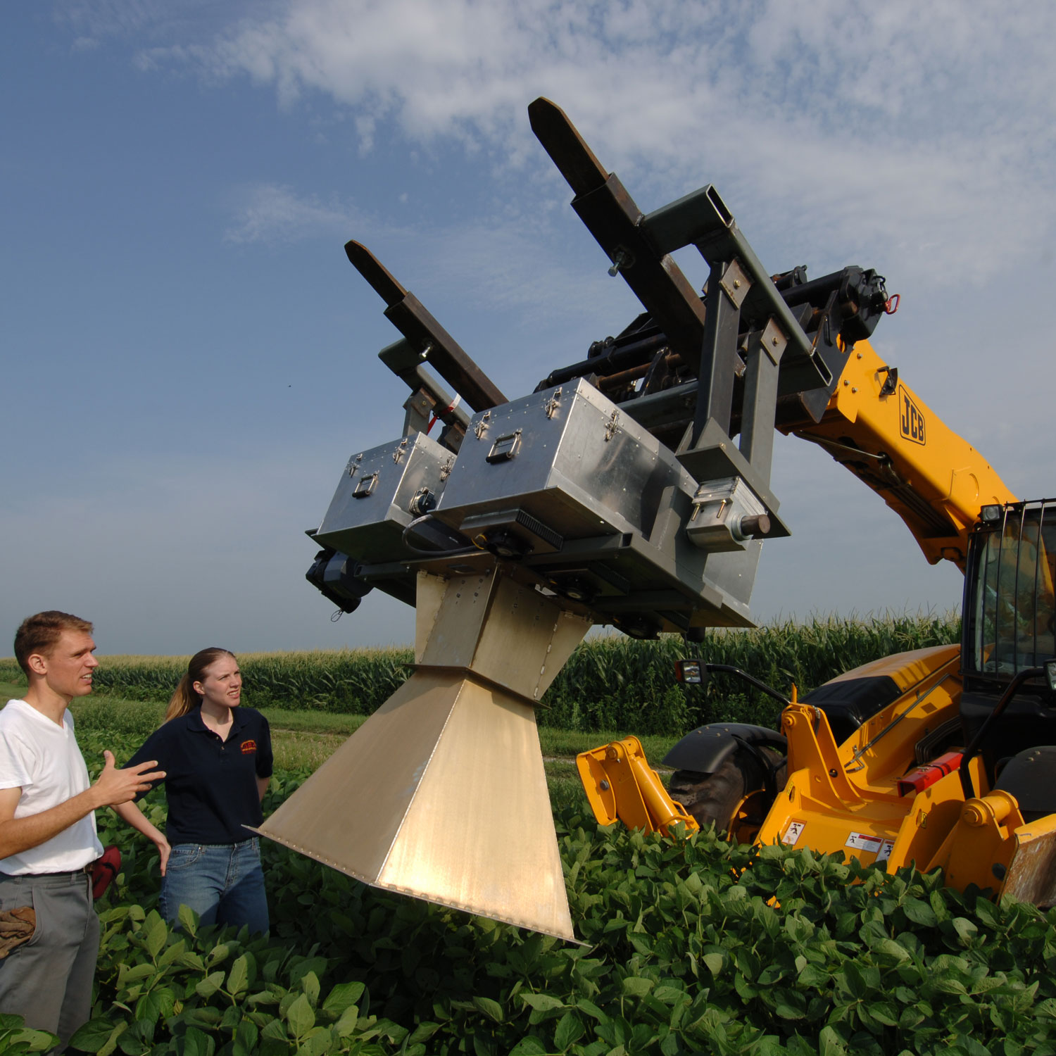 People in field working with heavy equipment