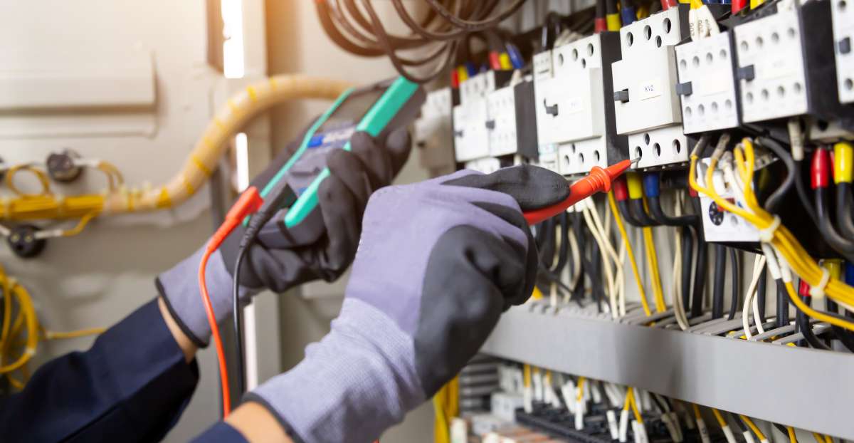 Electrician engineer tests electrical installations and wires on relay protection system